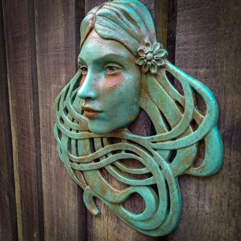 Art Nouveau inspired sculpture of beautiful female face with long stylised hair